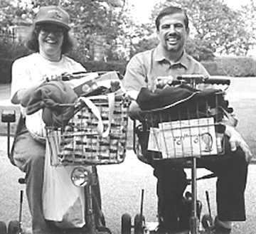 Photo of Ellen and Jerry Nuzzi sitting in their scooters at a park